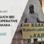 Mann aus Ruanda hält Schild der Kaffee-Kooperative Koakaka