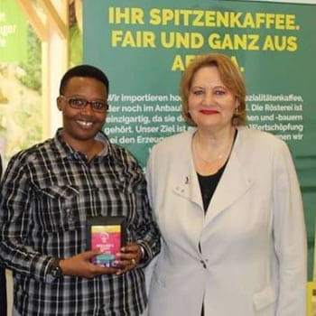Bäuerin aus Ruanda hält TERRE DES FEMMES FINEST Aroma Kaffee in Ihren Händen