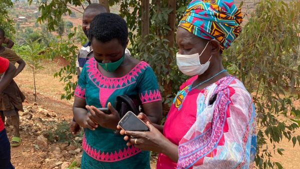 Bäuerinnen mit Handy in der Hand.